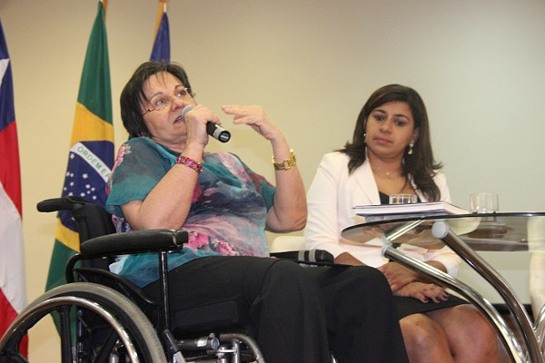 Fotografia de Maria da Penha, mulher que deu nome à Lei Maria da Penha, dando uma palestra sobre violência doméstica.