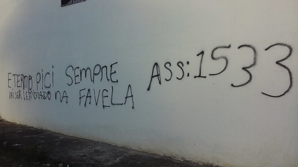Frase e assinatura “1533”, do PCC, em uma parede.