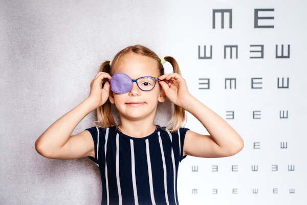 Criança fazendo exame de vista, uma alusão à ambliopia.