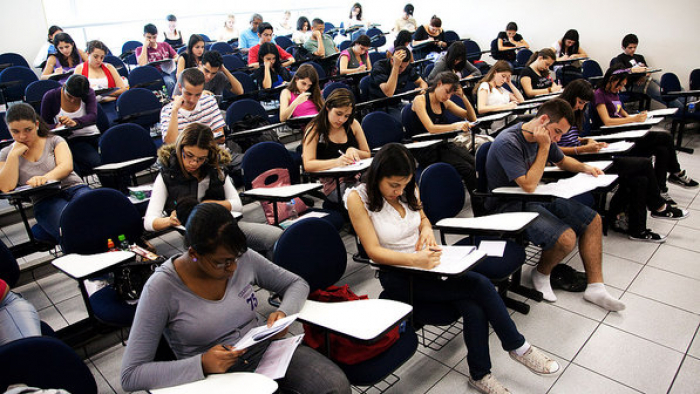 Estudantes sentados fazendo a prova do Encceja.