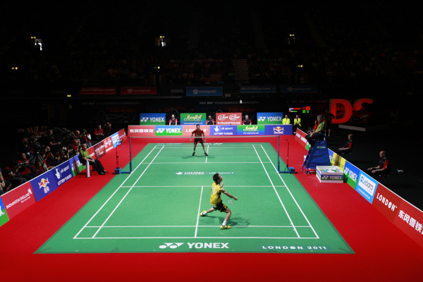 Dois atletas jogando badminton em um torneio.