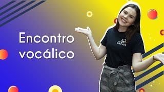 Título "Encontro vocálico" escrito com professora ao lado, em fundo roxo e amarelo.