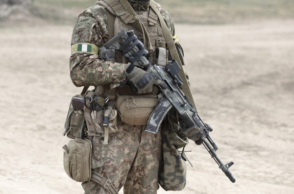Fotografia, do pescoço para abaixo, de soltado nigeriano, cujo exército luta contra o Boko Haram.