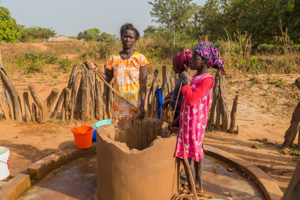 Mulheres tirando água de um poço em Guiné-Bissau.