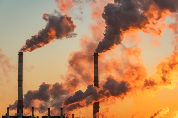 Indústria emitindo gases poluentes, situação que contribui para os aumentos nos níveis de dióxido de carbono (CO₂).
