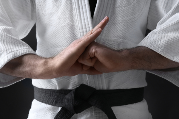 Homem fazendo gesto de karate com as mãos.