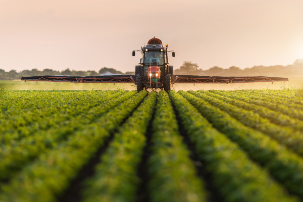 Pulverização de pesticidas em uma plantação, uma alusão à agropecuária no Brasil.