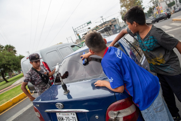 Crianças lavando um carro, um exemplo cotidiano de trabalho infantil.