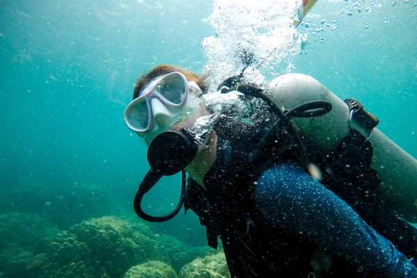 Pessoa mergulhando com um tubo de oxigênio e de nitrogênio.
