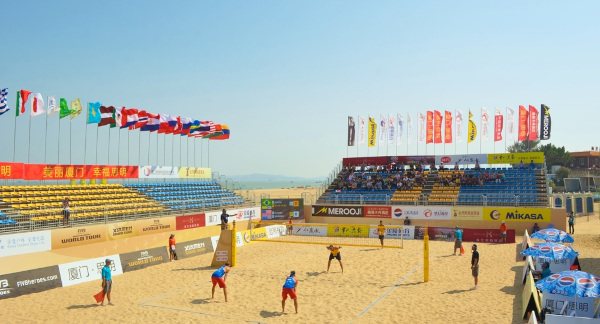Atletas jogando em uma quadra do vôlei de praia.