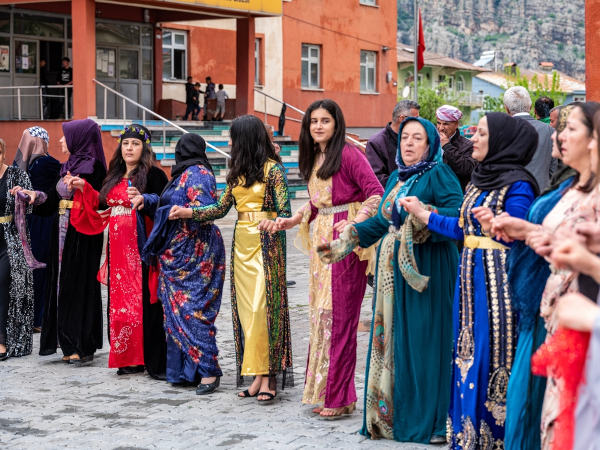 Mulheres curdas que vivem na Turquia usando roupas tradicionais, com muitas cores e diferentes padrões de estampa.