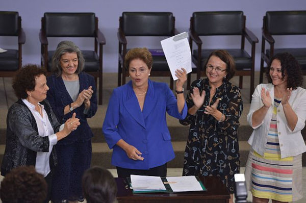 Dilma Rousseff e outras parlamentares celebrando a Lei do Feminicídio que protege os direitos da mulher.