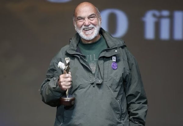 Lima Duarte com troféu na mão e sorrindo. 