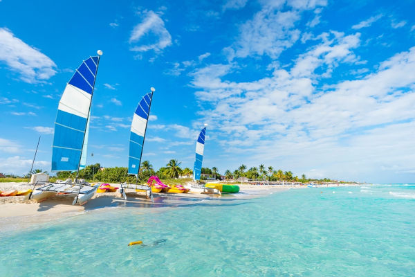 Pequenos barcos à vela em uma praia de Cuba.