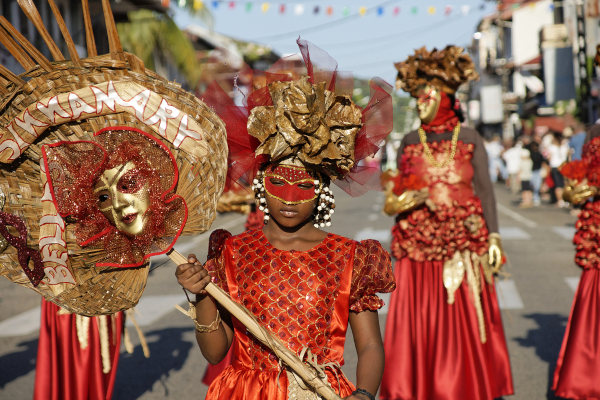 Mulheres com máscaras e trajes coloridos no desfile de Carnaval da Guiana Francesa.