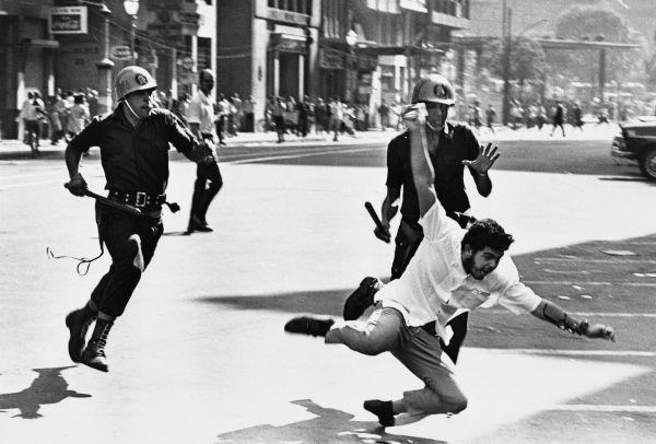 Policiais perseguindo estudante anos após o Golpe Militar de 1964 (ou Golpe Civil-Militar de 1964).