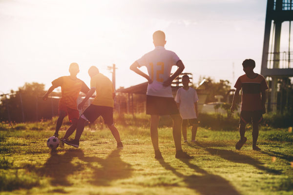 Jovens jogando futebol, um exemplo de ação social.