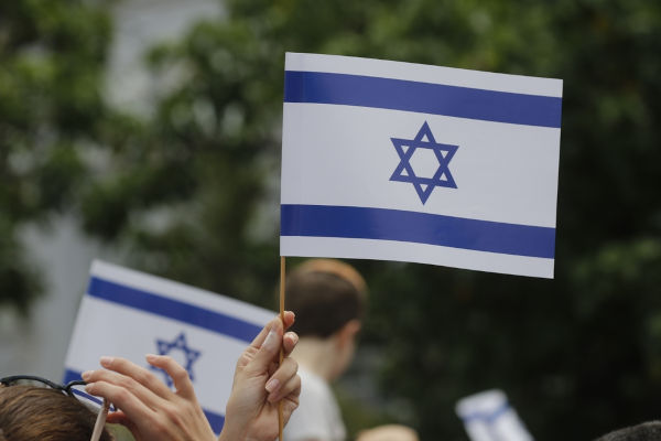 Mão segurando a Bandeira de Israel, em texto sobre sionismo.[imagem_principal]
