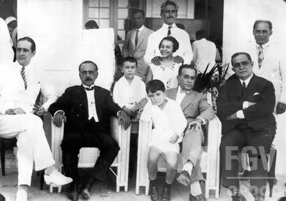 Getúlio Vargas e Darcy Sarmanho, sua esposa. Getúlio Vargas com criança no colo e rodeado de pessoas.