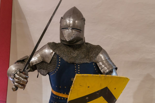 Cavalheiro medieval segurando espada e escudo, membro da sociedade estamental feudal.