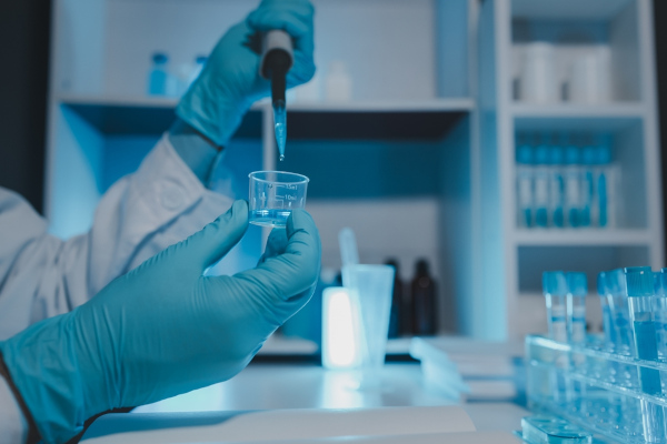 Mãos fazendo um experimento em laboratório, em texto sobre molalidade.