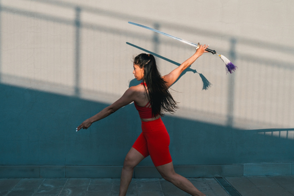 Mulher segura bastão longo de kung fu.