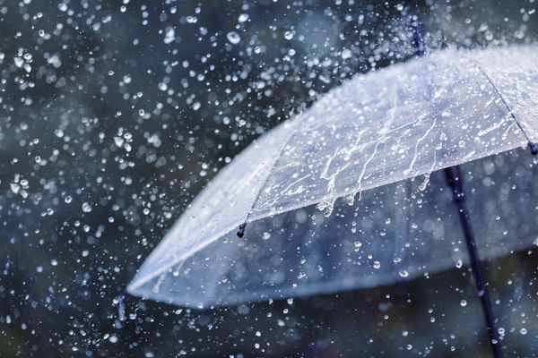 Água da chuva caindo em um guarda-chuva.