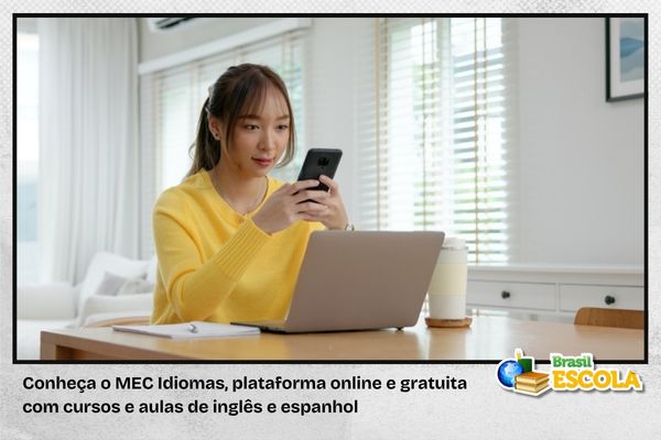 Estudante de amarelo com celular e computador
