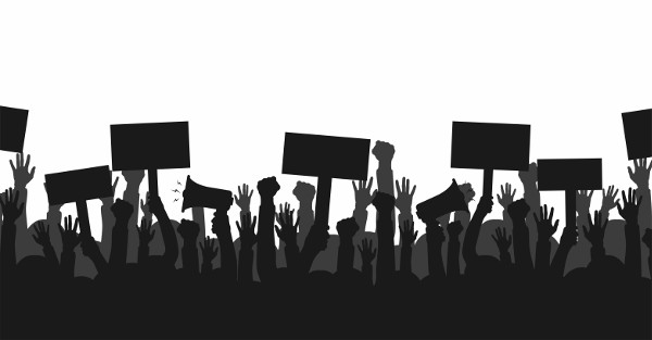 Imagem em preto e branco de braços humanos segurando cartazes e com punho em riste, em alusão ao conceito de democracia.