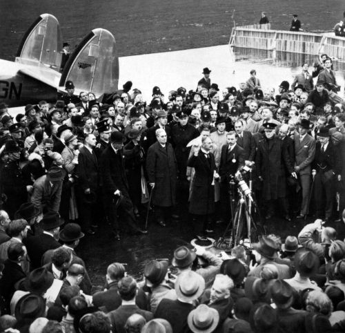 Neville Chamberlain, primeiro-ministro britânico, mostra o papel do acordo realizado na Conferência de Munique em 1938