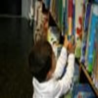 Criança na biblioteca descobrindo a leitura