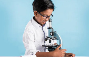 criança olhando microscópio