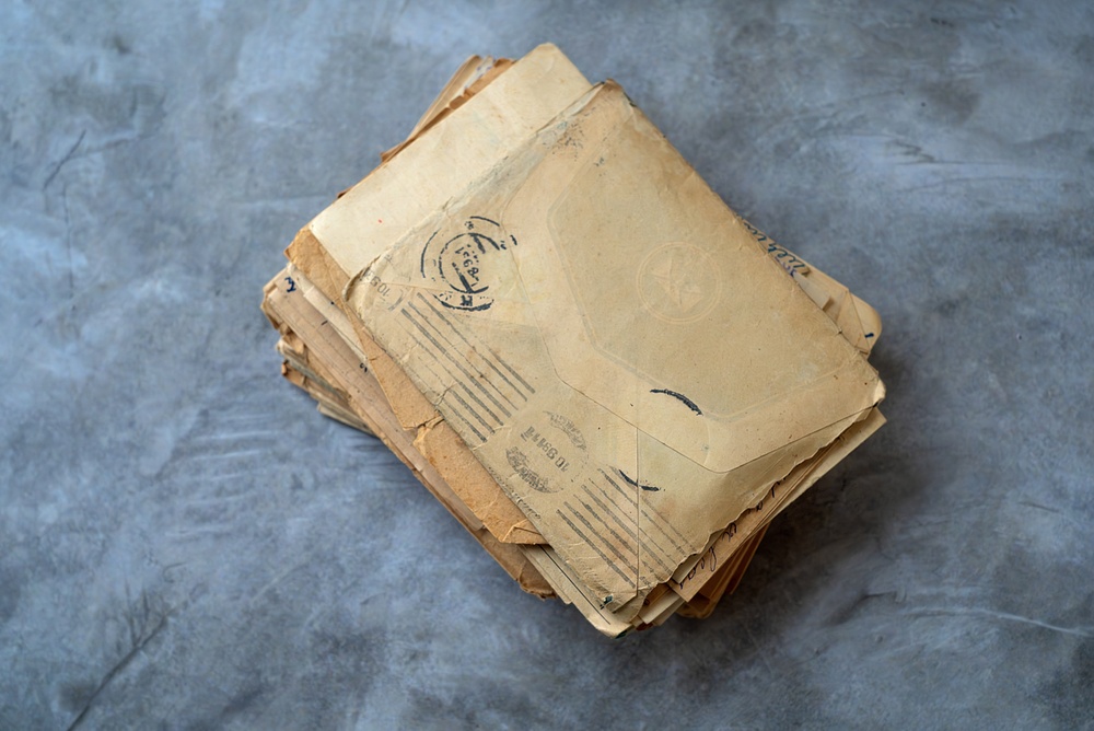 Documentos com a aparência de serem antigos sobre uma mesa, um dos aspectos que podem estar relacionados à grilagem.