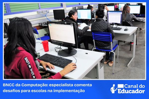 Estudantes utilizando computadores em laboratório na escola