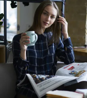Estudante com jornal e café