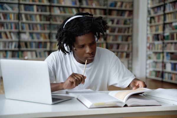 Estudante com cabelo escuro comprido segurando quadro