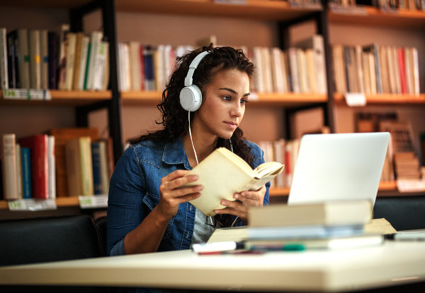 Mulher ouvindo música enquanto estuda.