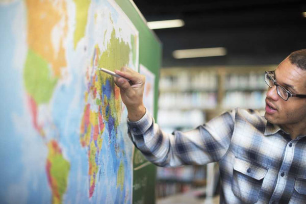Professor de Geografia mostrando o Mapa-Múndi.