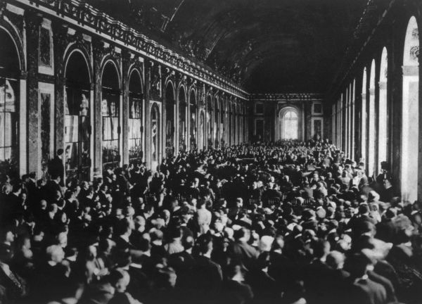 Delegações reunidas durante a assinatura do Tratado de Versalhes na Galeria dos Espelhos, em 1919.
