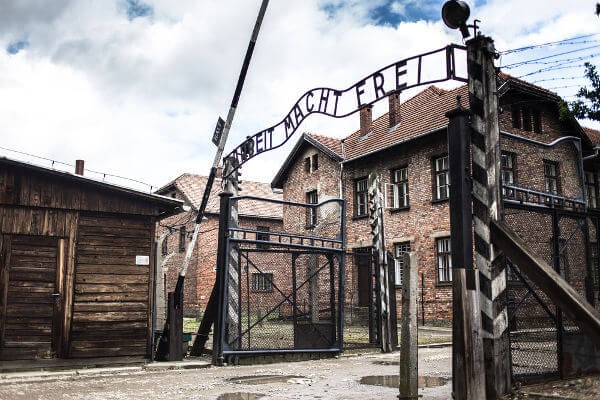 Entrada de Auschwitz, campo de extermínio responsável pela morte de 1,2 milhão de pessoas. No portal está escrito “o trabalho liberta”.***