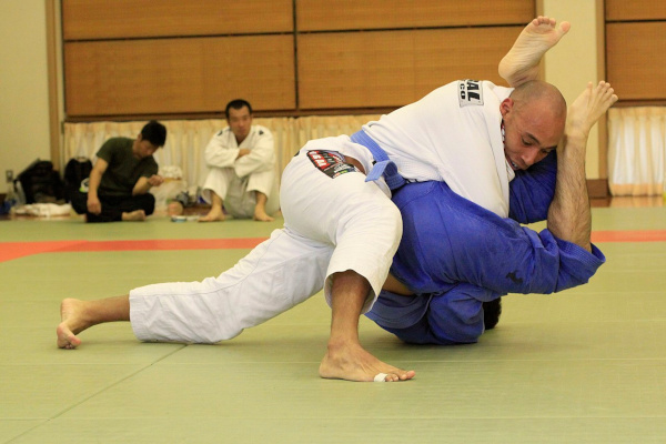 Dois homens lutando jiu-jitsu brasileiro, uma invenção de brasileiros.