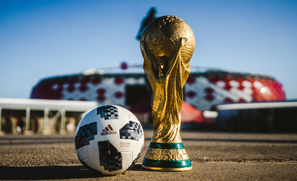 Foto da bola da Copa do Mundo de 2018 ao lado de uma taça da competição.