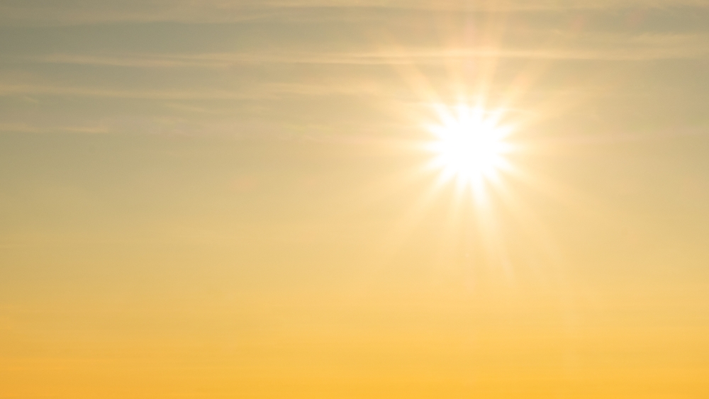 Sol brilhando em céu alaranjado, representando o aquecimento da Terra durante o Mioceno.