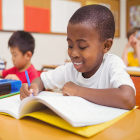 Criança negra escrevendo em caderno